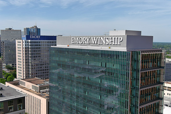 Roof tops of Winship at Emory Midtown and Emory University Hospital Midtown among the Atlanta skyline.