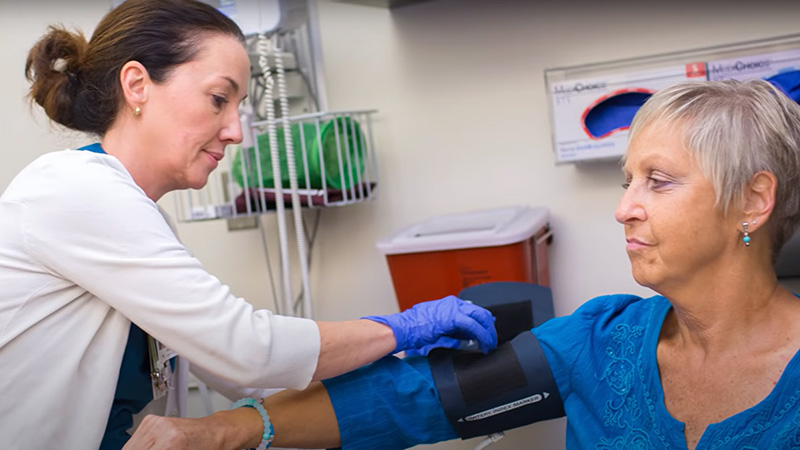 Infusion nurse taking a patient's blood pressure.