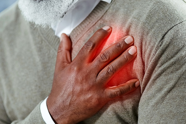 Middle aged man with hand on his chest due to heart pain (stock image)
