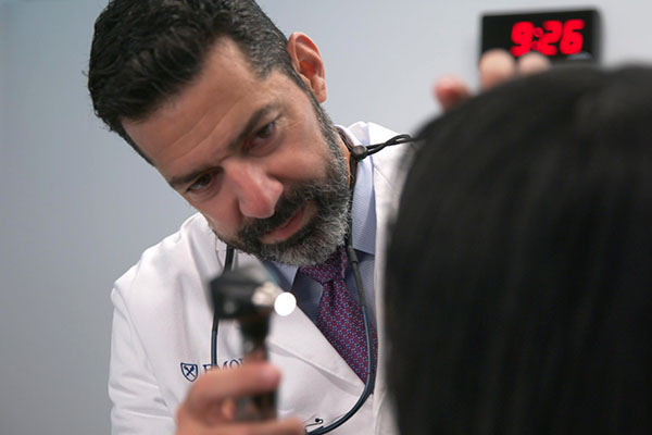 Physician examining a patient's throat.