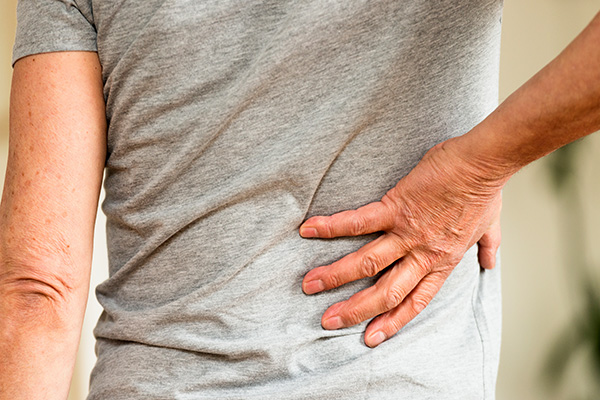 Man with hand on lower back. (Stock image)