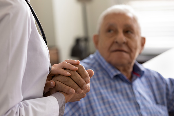 Doctor consoling retired aged man (stock image)