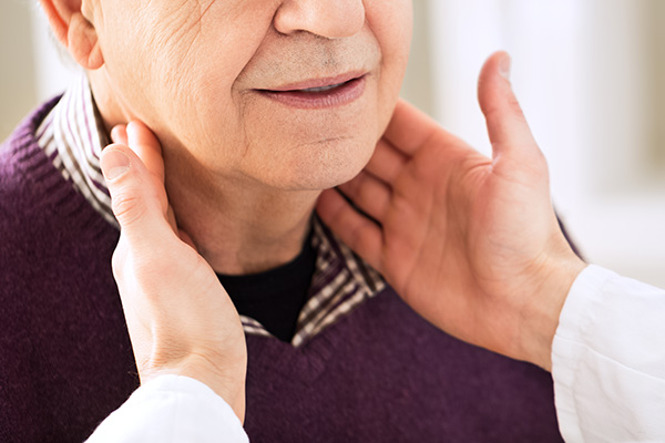 Clinician examining lymph nodes on patient's neck