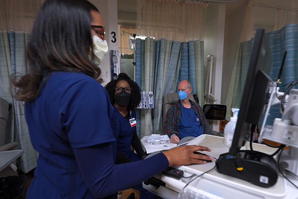 Oncology nurses with a patient in an infusion bay