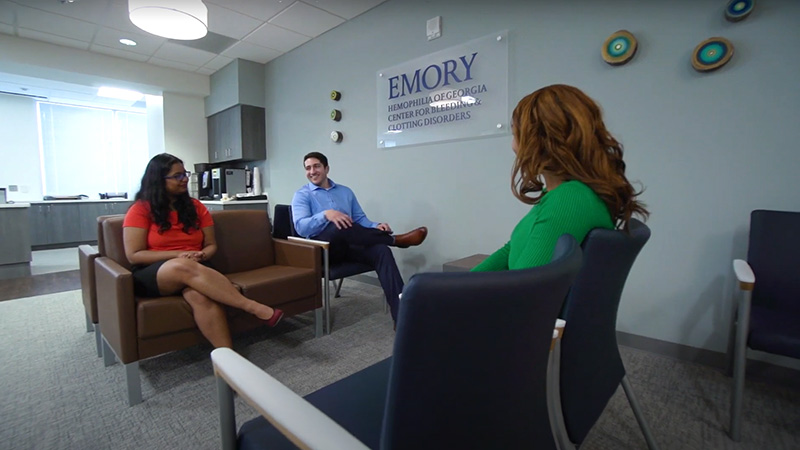 Three young adults in waiting area of bleeding disorders clinic.