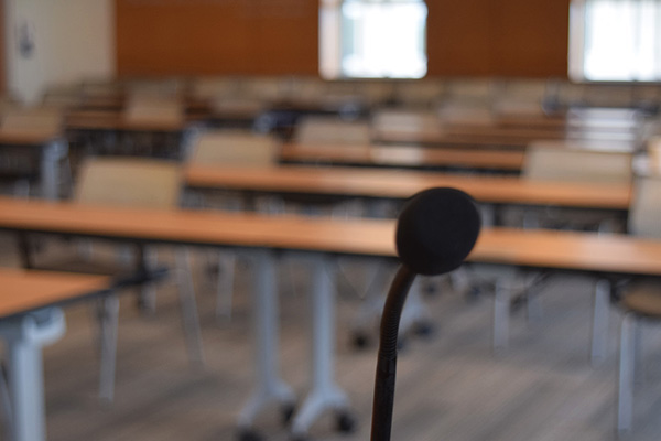 Close up of microphone at podium looking out into empty conference room