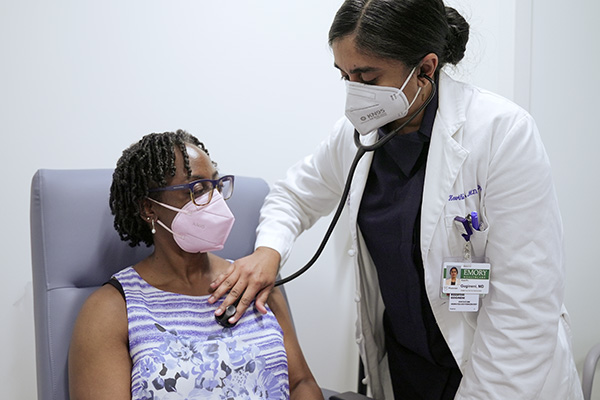 Winship breast oncologist Dr. Keerthi Gogineni evaluates a patient using a stethoscope