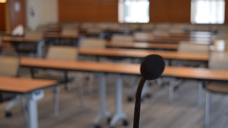 Close up of microphone at podium looking out into empty conference room