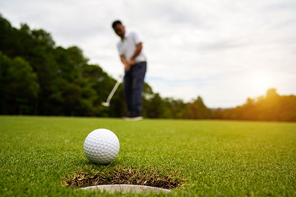 Golfer putting on green.