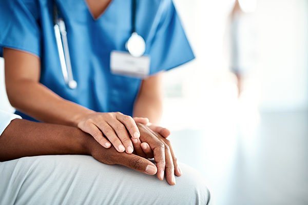 Nurse holding patient's hands. (Stock image)