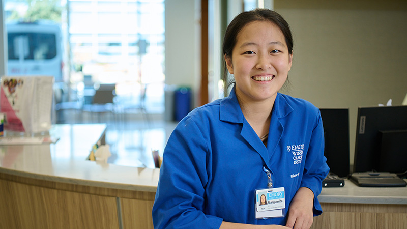 Volunteer smiling at the registration desk at Winship Cancer Institute