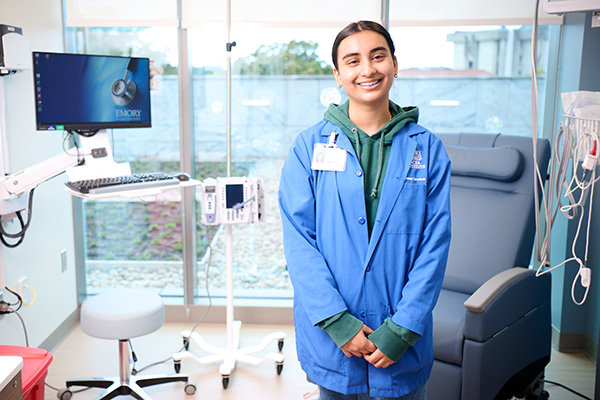 Winship college volunteer standing in exam room