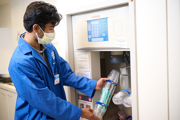 Winship volunteer uploads tube with lab sample