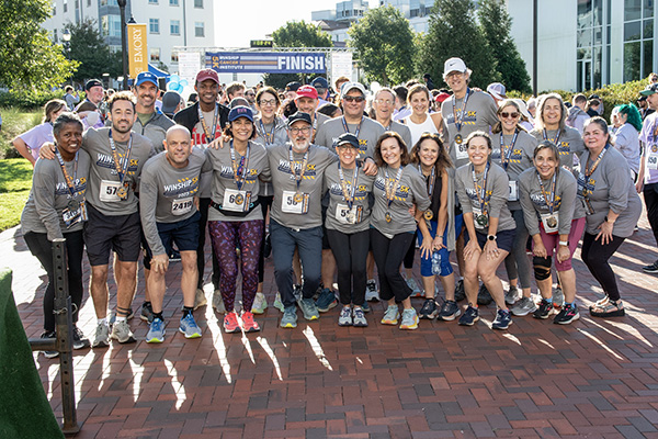 Group of Winship 5K participants posing together with their finish medals