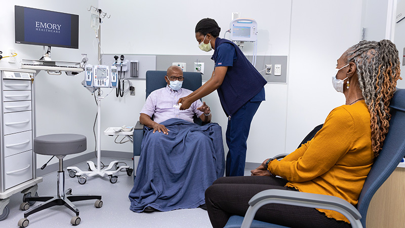 Oncology nurse with patient in exam room