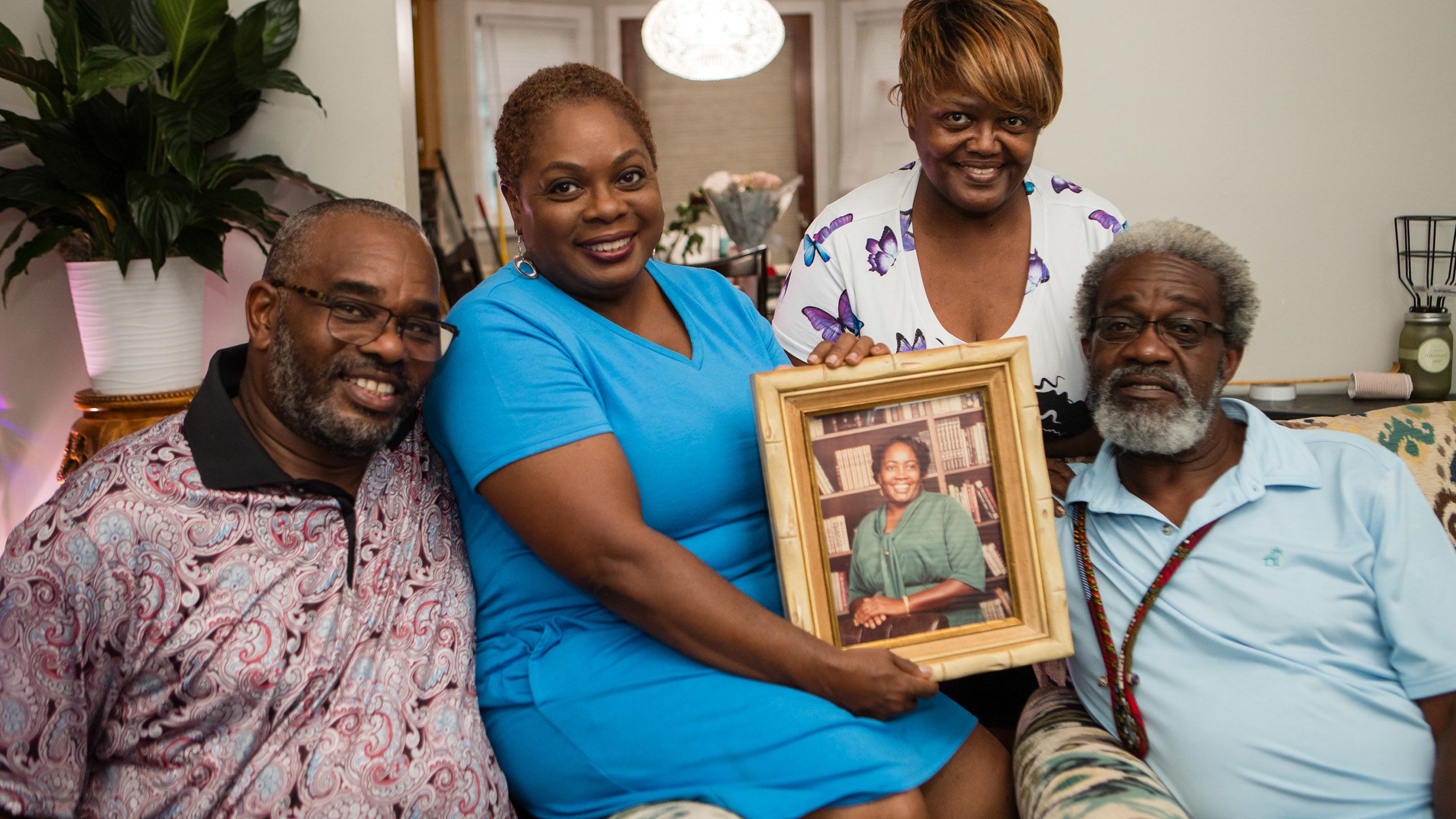 Vance family grouped together with a framed picture of their mother.