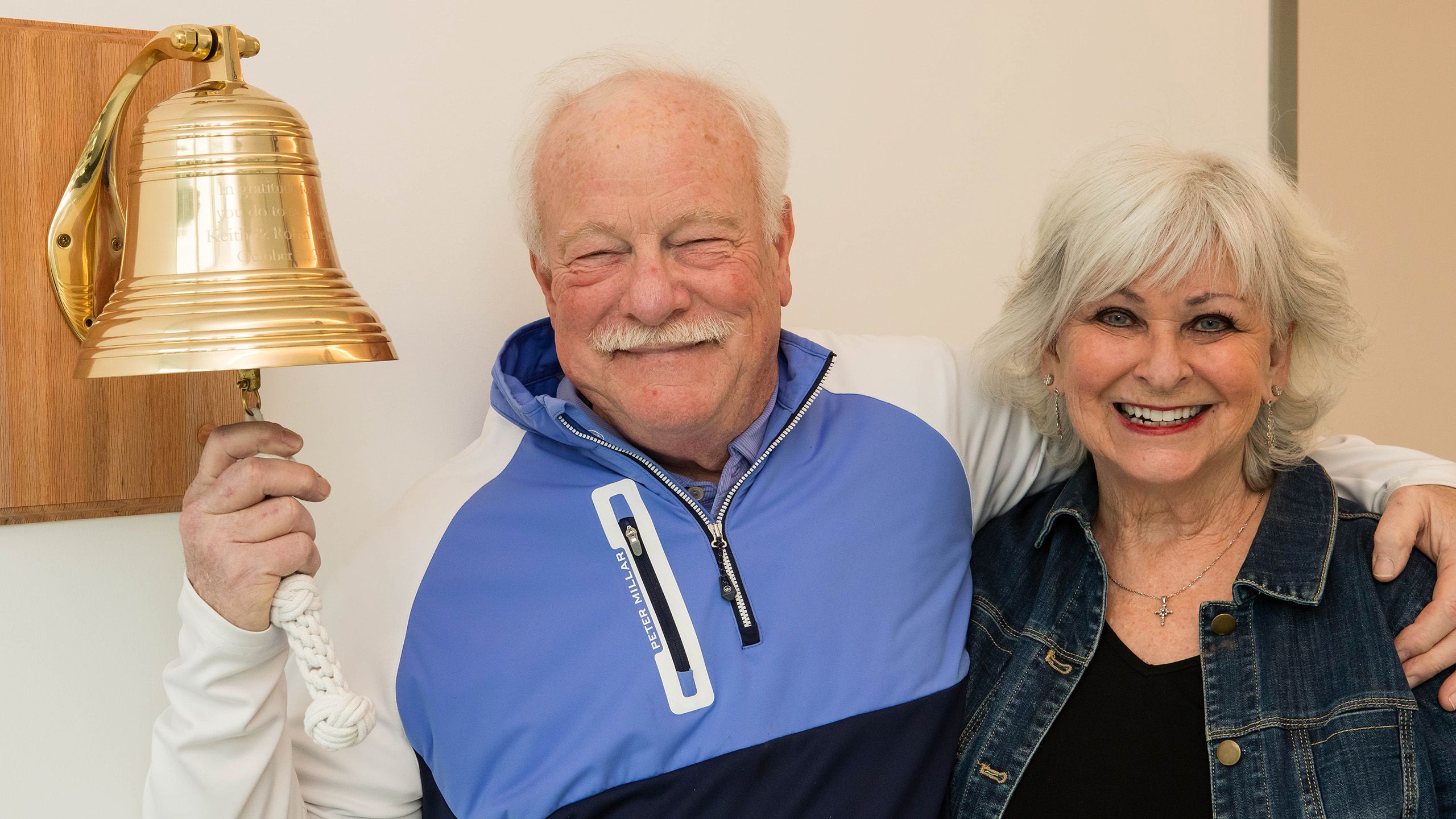 Keith ringing bell with his wife Robin by his side