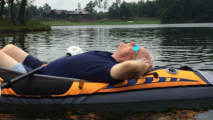 Keith laying back in a kayak on a lake