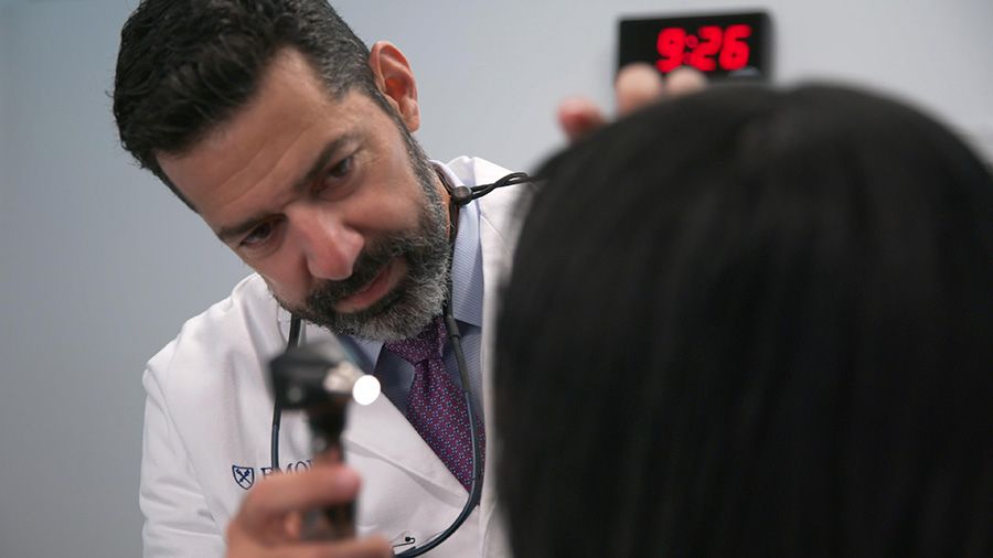 Mark El-Deiry, MD, head and neck surgeon examining a patient