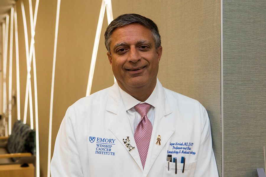 Portrait of a doctor leaning against a wall.