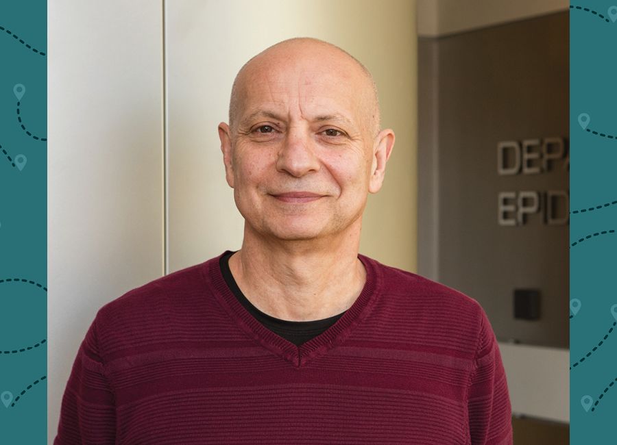 a portrait of a bald man with a maroon sweater and smiling to the camera.