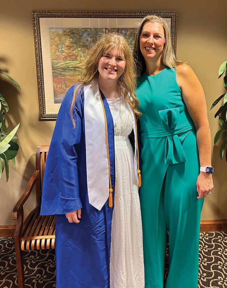 a photography of a mother and daughter attending daughter's high school graduation ceremony.
