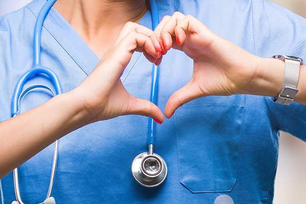Nurse holding her fingers in the shape of a heart (stock image)