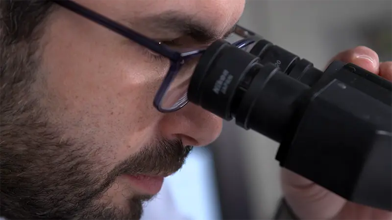 Dr. El-Rassi peering into a microscope.