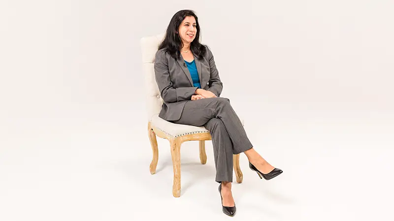 A woman sitting in a chair during a video interview.