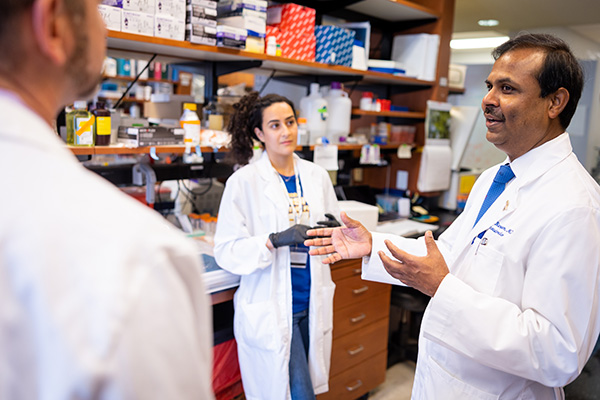 Dr. Suresh Ramalingam in the lab with Dr. Adam Marcus and a research trainee