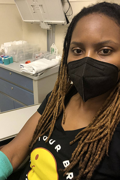 Brandi wearing a mask in an exam room