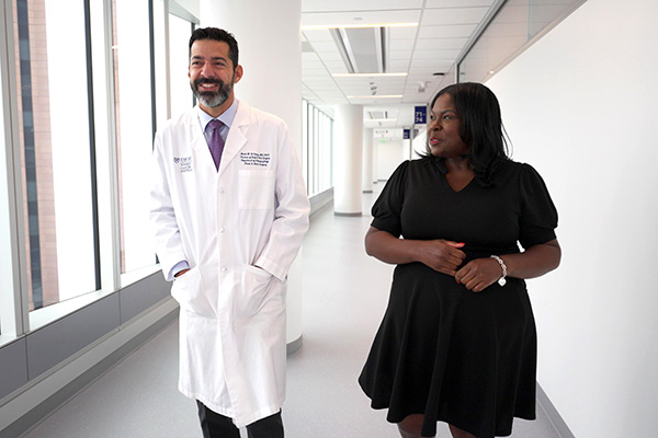 Dr. Mark El-Deiry and Trina walking together down hallway