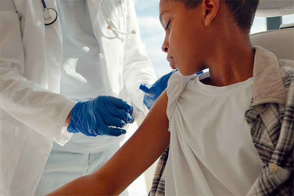 Clinician placing an adhesive bandage on a pediatric patient's arm. (stock image)